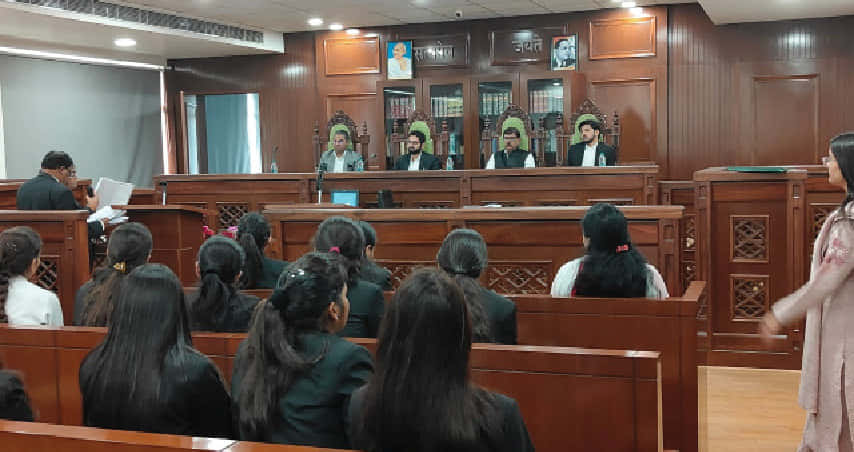 Law students practicing in IAMR's moot court room with judges panel seated.