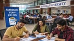 **Alt Text:** Students filling out admission forms inside Kalinga University campus building, sitting at tables in the admission office while staff assist in the background.